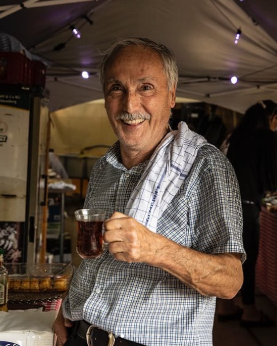 Papa lächelnd mit einem Glas Çay am Stand des Cinema Paradiso
